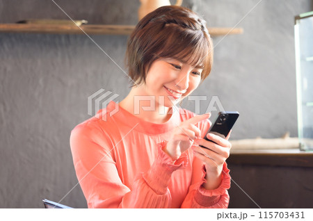 カフェでスマホを見る女性 カフェでスマホを見る女性 115703431