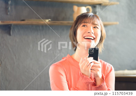 カフェでスマホを見る女性　 115703439