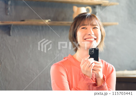 カフェでスマホを見る女性　 115703441