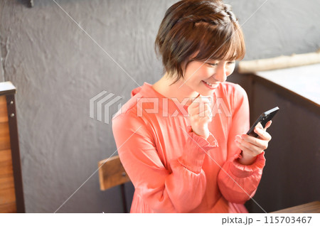 カフェでスマホを見る女性　 115703467