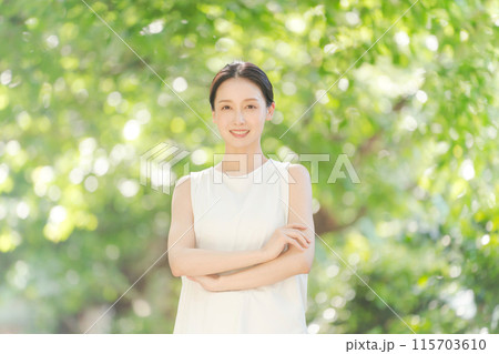 新緑の中で微笑む20代女性 新緑の中で微笑む20代女性 115703610