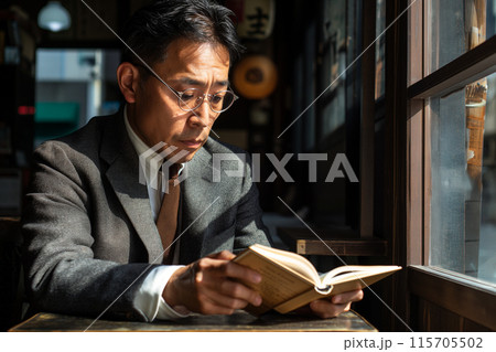 カフェで本を読むビジネスマン 115705502