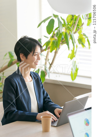 明るいオフィスで打ち合わせをする女性 115706506