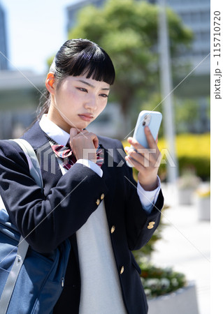 スマホを持って悩む女子高生 スマホを持って悩む女子高生 115710720