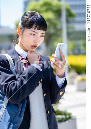 スマホを持って悩む女子高生 スマホを持って悩む女子高生 115710721
