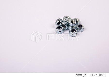 Bunch of zinc plated self locking hexagon nuts on white background, place for text Bunch of zinc plated self locking hexagon nuts on white background, place for text 115710807