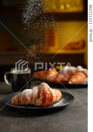 Croissants sprinkled with sugar powder. 115711396