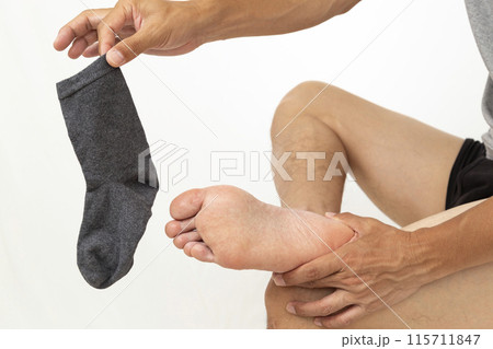 靴下を摘んで持つ男性の手元 白バック 靴下を摘んで持つ男性の手元 白バック 115711847