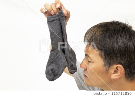 靴下を摘んで持つ男性　白バック 115711850