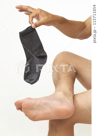 靴下を摘んで持つ男性の手元 白バック 靴下を摘んで持つ男性の手元 白バック 115711854