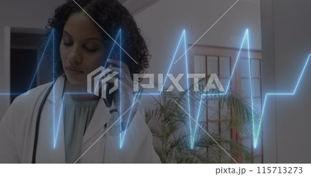 Image of cardiograph over happy biracial female doctor talking on smartphone 115713273