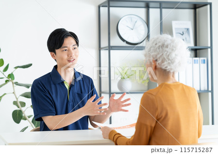 シニアの女性にケアプランを説明するケアマネージャー 115715287