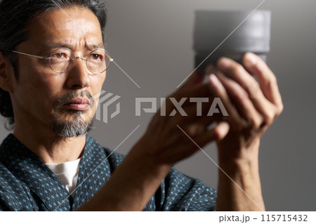 陶磁器を見つめる和服の男性　陶芸家　鑑定家　イメージ 115715432
