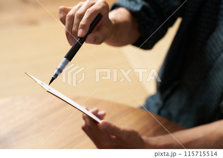 筆ペンで短冊に文字を書く男性の手元 筆ペンで短冊に文字を書く男性の手元 115715514