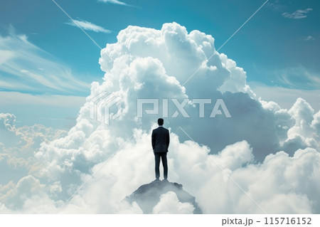 A man stands on a mountain top, looking up at the sky 115716152