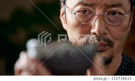 陶磁器を見つめる和服の男性 陶芸家 鑑定家 イメージ 陶磁器を見つめる和服の男性 陶芸家 鑑定家 イメージ 115716613