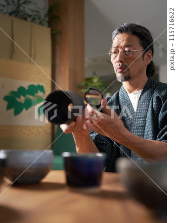 陶磁器をルーペで確認する和服の男性　鑑定家　イメージ 115716622