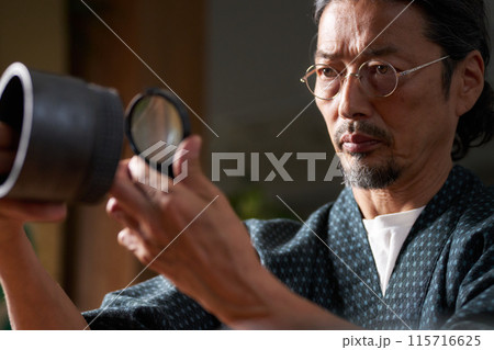 陶磁器をルーペで確認する和服の男性 鑑定家 イメージ 陶磁器をルーペで確認する和服の男性 鑑定家 イメージ 115716625