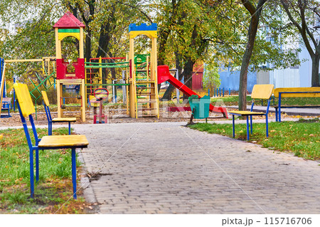 Summer autumn children's playground with painted toy slide in public park 115716706