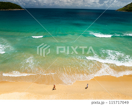 Top view beach with waves crashing on sandy shore,Beautiful waves sea surface in summer seascape background,Amazing beach colorful water background 115717049
