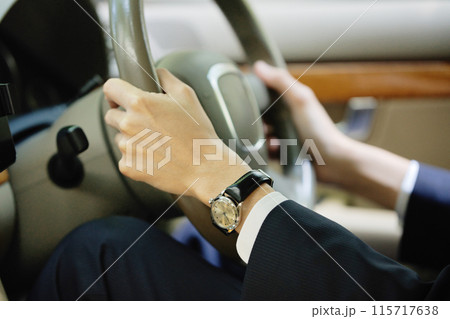 ハンドルを握るスーツの若い男性 115717638