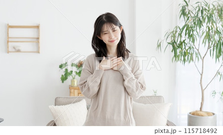 胸に手を当て幸せを感じる女性 胸に手を当て幸せを感じる女性 115718492