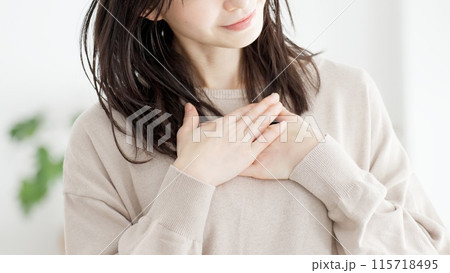 胸に手を当て幸せを感じる女性 115718495