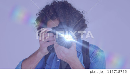 Spot of light against african american male photographer clicking pictures with digital camera 115718756