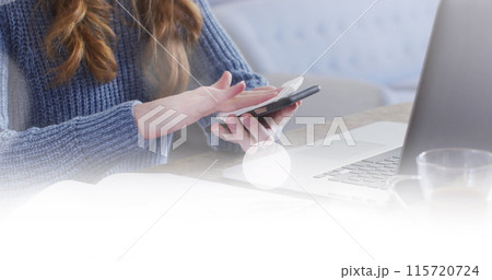 Image of white spots over caucasian woman wiping smartphone using laptop at home Image of white spots over caucasian woman wiping smartphone using laptop at home 115720724