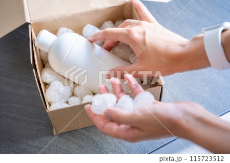 Eco packaging of parcels and white biodegradable filler. Box is filled with a filler safety for environment. Delivery of goods, parcels, delivery service, nature protection and recycling concept 115723512