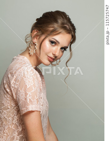 Cheerful glam woman fashion model with makeup and updo hairstyle on gray studio background Cheerful glam woman fashion model with makeup and updo hairstyle on gray studio background 115725747