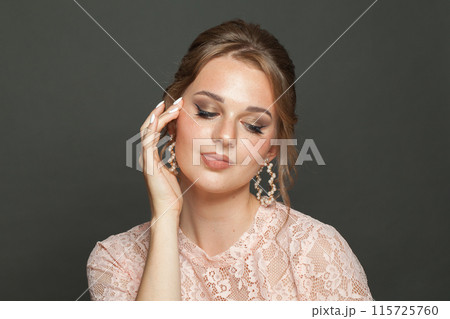 Natural glam woman fashion model with makeup and updo hairstyle on black studio background Natural glam woman fashion model with makeup and updo hairstyle on black studio background 115725760