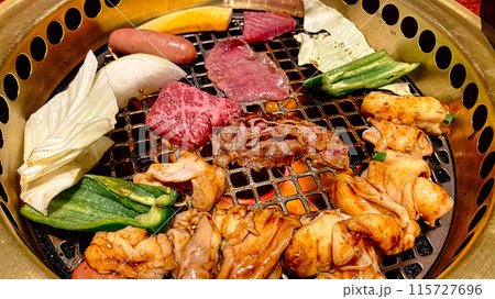 卓上コンロに焼肉と野菜を乗せて焼く 卓上コンロに焼肉と野菜を乗せて焼く 115727696