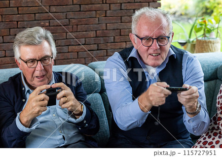 Elderly Senior Citizens Enjoying Competitive Video Games with Joy and Enthusiasm Elderly Senior Citizens Enjoying Competitive Video Games with Joy and Enthusiasm 115727951