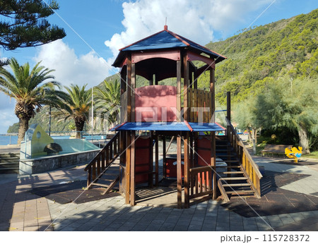 Riva Trigoso, Sestri Levante, Liguria, Italy, September 21, 2023: view of childrens playground in Riva Trigoso village with sea view, bench and palm trees at sunny day 115728372