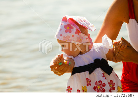 Mother playing with baby on beach 115728697