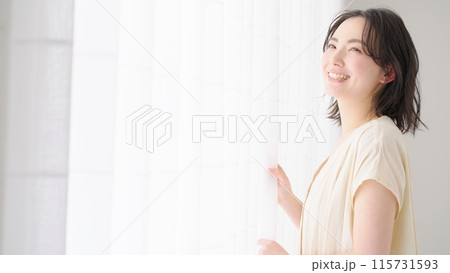 カーテンの前に立つ若い女性 カーテンの前に立つ若い女性 115731593