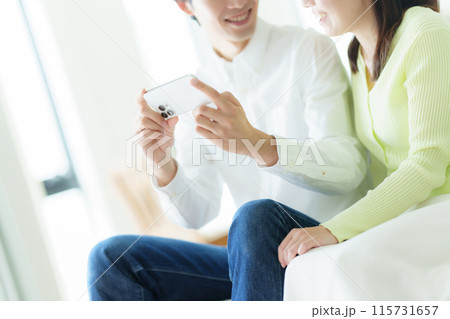 スマホを見る夫婦 スマホを見る夫婦 115731657