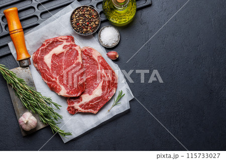 Raw ribeye steaks with savory spices Raw ribeye steaks with savory spices 115733027