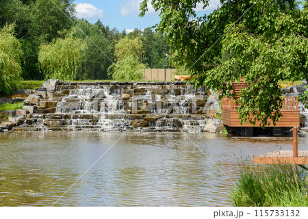 A cascade of an artificially created waterfall made of stone steps. A cascade of an artificially created waterfall made of stone steps. 115733132