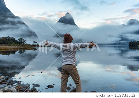 Female tourist enjoying with the Milford sound with Mitre peak and foggy on the lake view 115733312