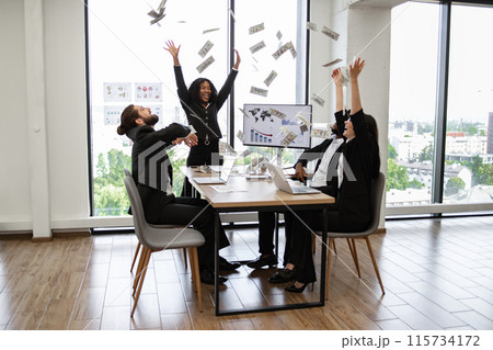 Business team celebrating success with money flying in office 115734172