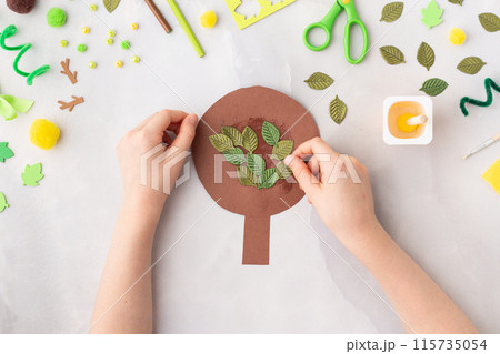 Paper tree with green leaves summer idea for kids craft in kindergarten hands Paper tree with green leaves summer idea for kids craft in kindergarten hands 115735054
