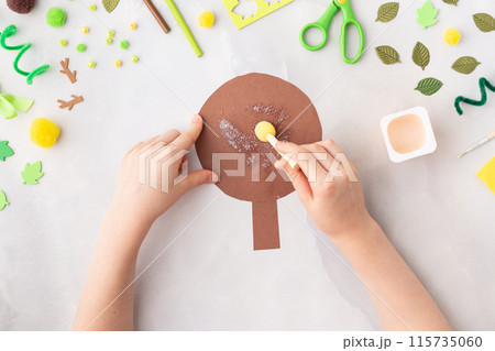 Paper tree with green leaves summer idea for kids craft in kindergarten hands Paper tree with green leaves summer idea for kids craft in kindergarten hands 115735060