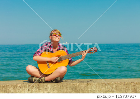 Young woman with guitar outdoor 115737917
