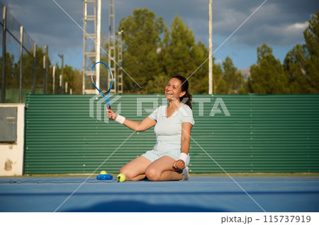 Woman enjoying a fun moment on a tennis court 115737919