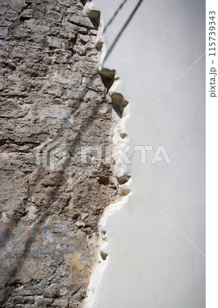 White stucco and brick wall texture. piece of brick wall under plaster 115739343