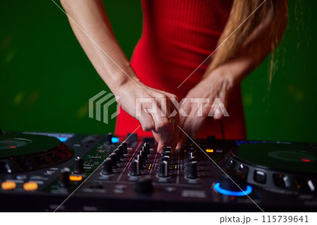 control DJ for mixing music with blurred people dancing at party in nightclub. 115739641