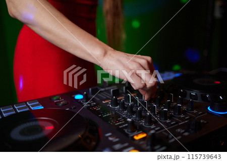 control DJ for mixing music with blurred people dancing at party in nightclub. control DJ for mixing music with blurred people dancing at party in nightclub. 115739643