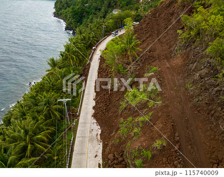 Flying over the road with rockfalls and mudslidesl from mountain cliff. Philippines. 115740009